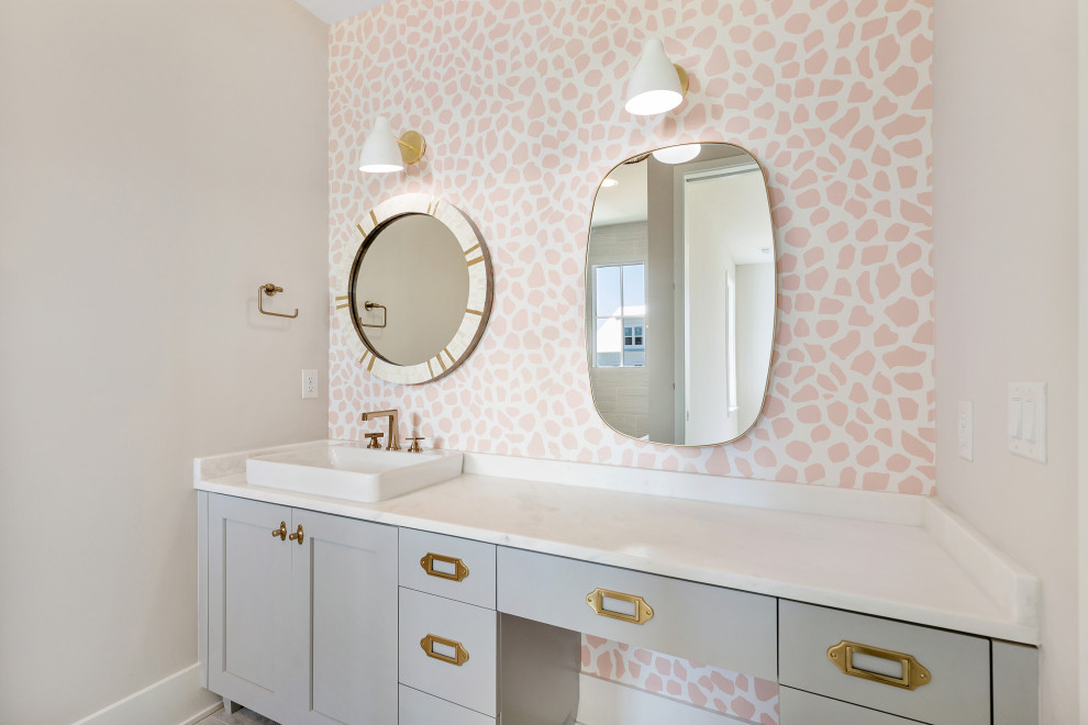 Photo of a modern kids bathroom in Charleston with grey cabinets, pink walls, marble benchtops, white benchtops, a single vanity, a freestanding vanity and wallpaper.