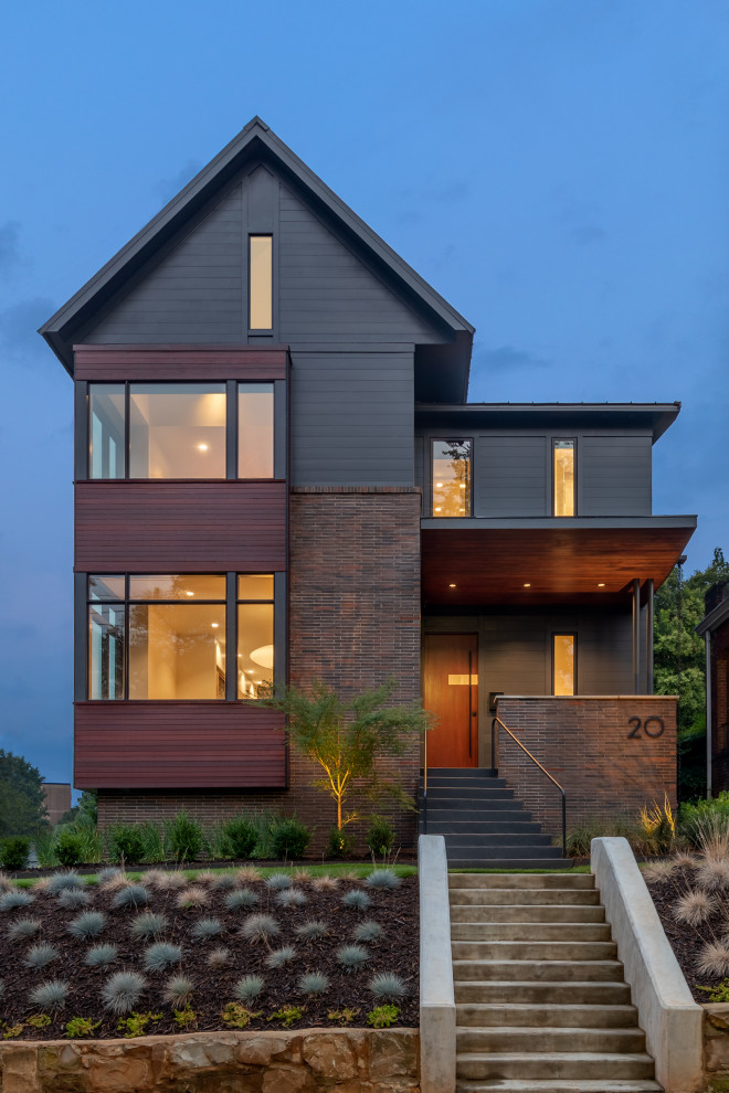 На фото: двухэтажный, серый частный загородный дом в современном стиле с двускатной крышей и отделкой планкеном с