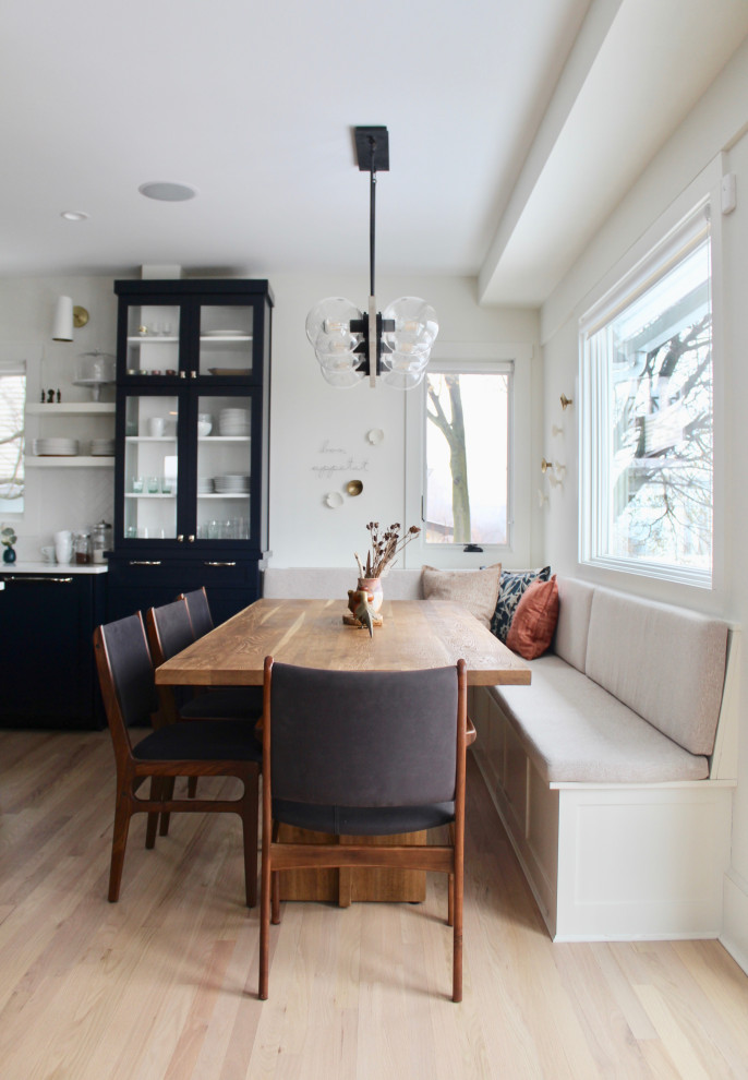 Esempio di una sala da pranzo aperta verso la cucina chic di medie dimensioni con pareti bianche e parquet chiaro