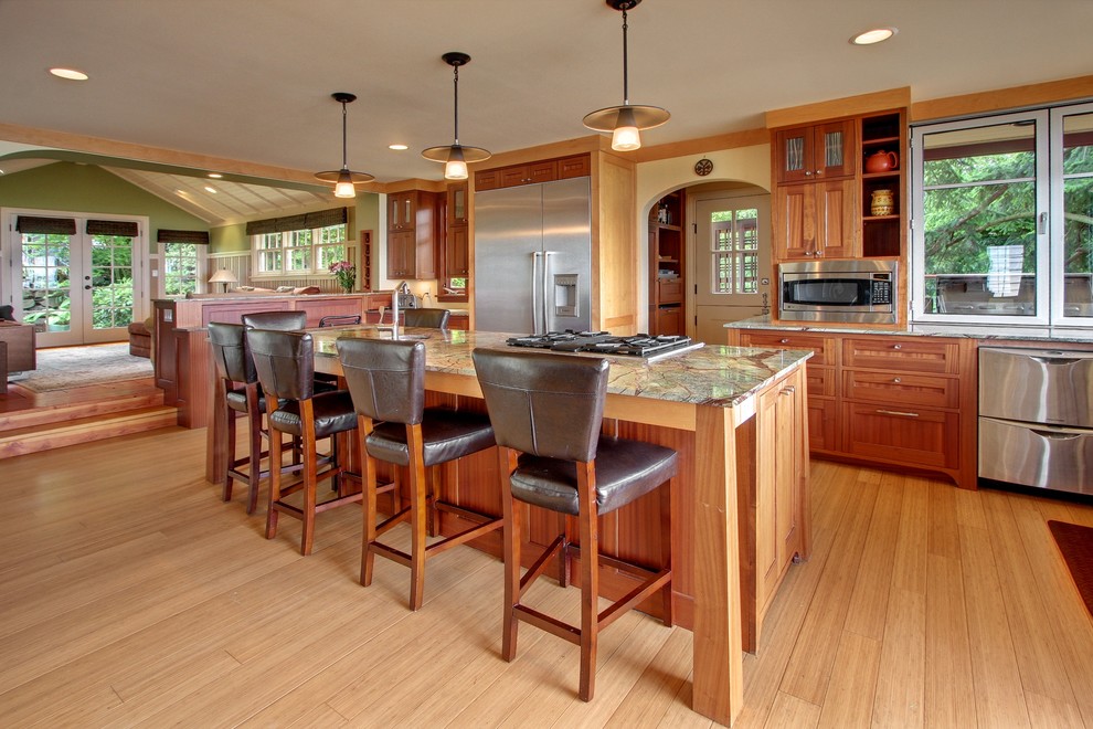 This is an example of an arts and crafts galley kitchen in Seattle with recessed-panel cabinets, medium wood cabinets, stainless steel appliances and light hardwood floors.