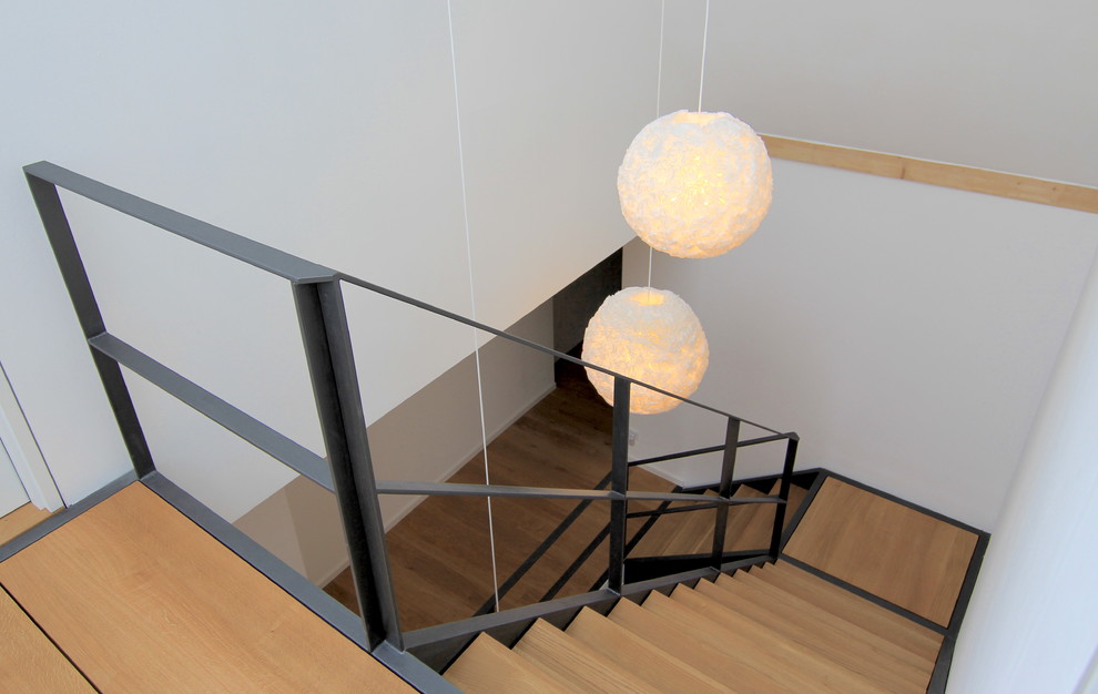 Geräumige Moderne Holztreppe in L-Form mit Stahlgeländer und offenen Setzstufen in Sonstige