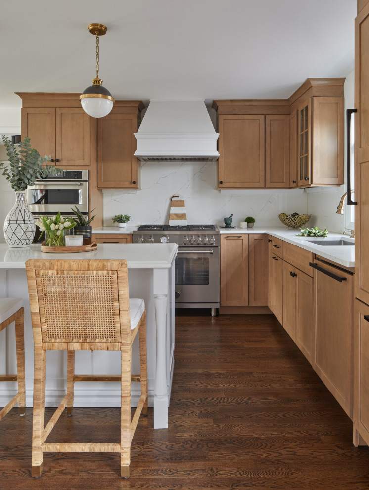 This is an example of a mid-sized traditional kitchen in New York with recessed-panel cabinets, light wood cabinets, quartz benchtops, white splashback, engineered quartz splashback, medium hardwood floors, with island and white benchtop.