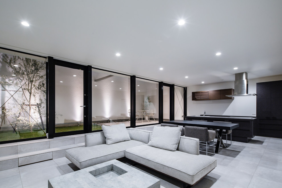 Large contemporary open concept living room in Other with white walls and grey floor.