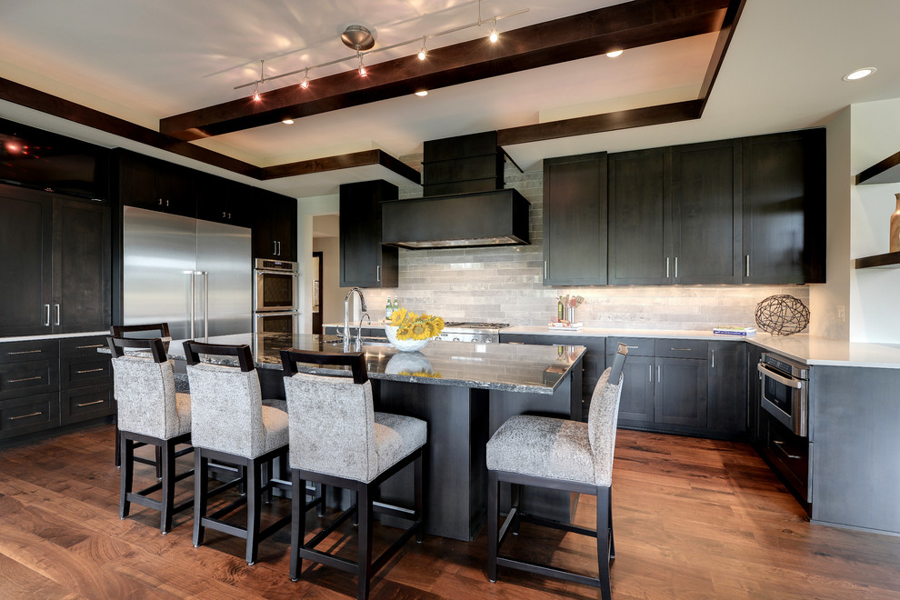 This is an example of a large transitional u-shaped kitchen in Minneapolis with an undermount sink, shaker cabinets, black cabinets and grey splashback.