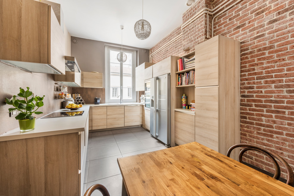 Mid-sized contemporary u-shaped separate kitchen in Lyon with laminate benchtops, brown splashback, stainless steel appliances, no island, flat-panel cabinets and light wood cabinets.