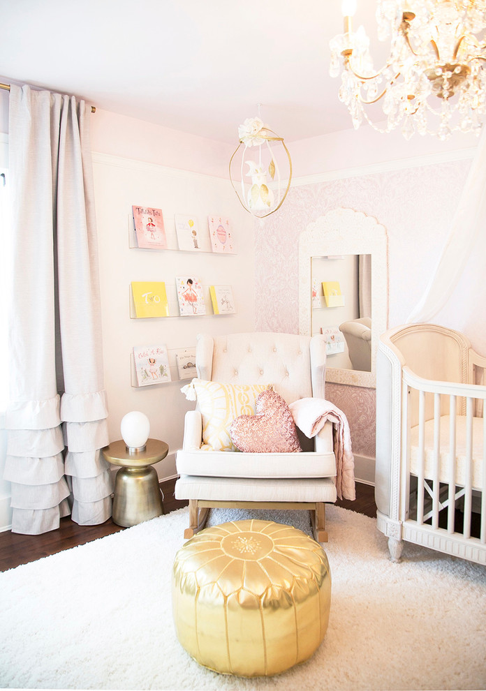 Photo of a contemporary nursery for girls in Vancouver with pink walls.