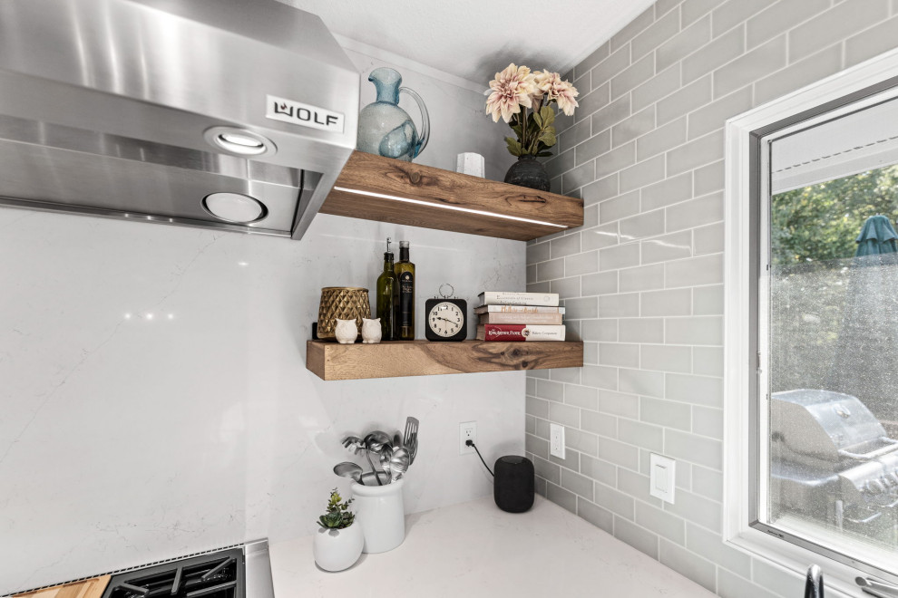 Inspiration for a large transitional u-shaped light wood floor and multicolored floor eat-in kitchen remodel with a single-bowl sink, shaker cabinets, white cabinets, quartz countertops, white backsplash, quartz backsplash, stainless steel appliances, an island and white countertops