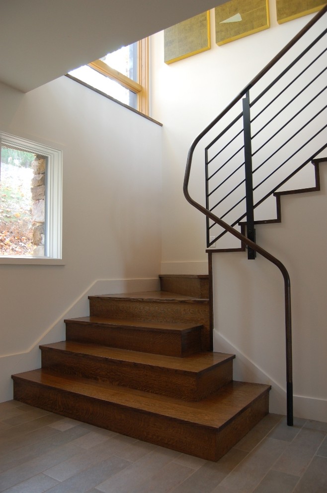 Contemporary wood staircase in Charlotte with wood risers.