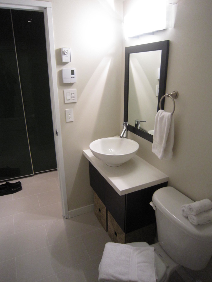 This is an example of a contemporary bathroom in Vancouver with a vessel sink, flat-panel cabinets, dark wood cabinets, engineered quartz benchtops, a two-piece toilet, white tile and porcelain tile.