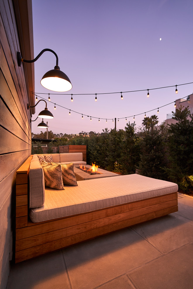 Inspiration for a small contemporary back patio in San Diego with a fire feature, natural stone paving and no cover.