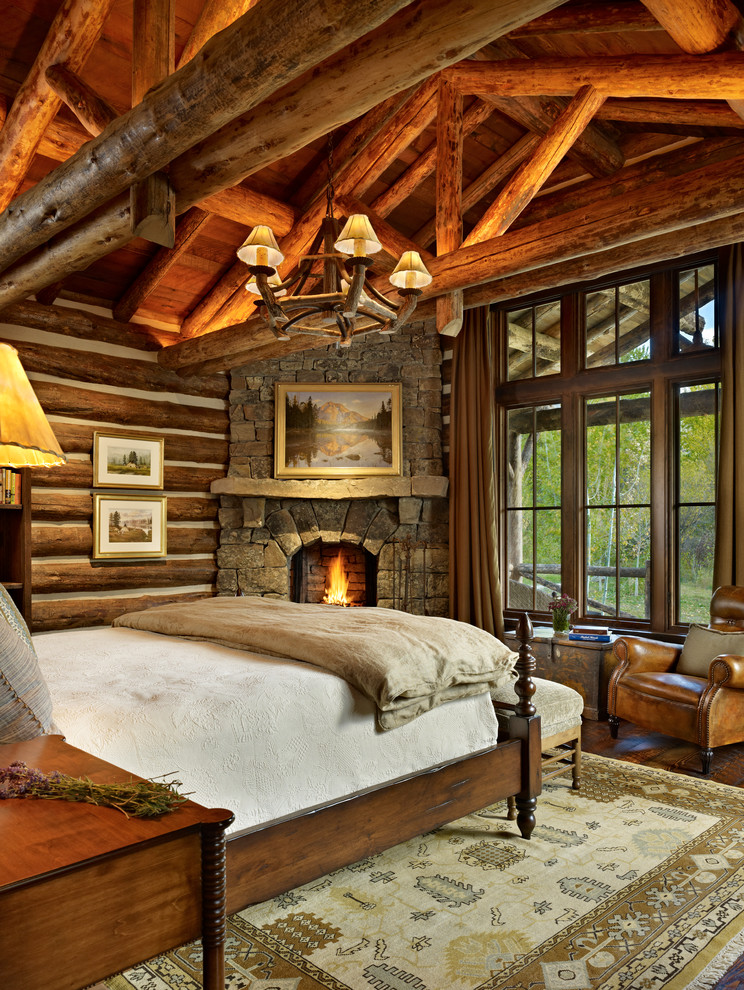 This is an example of a country bedroom in Other with a corner fireplace and a stone fireplace surround.