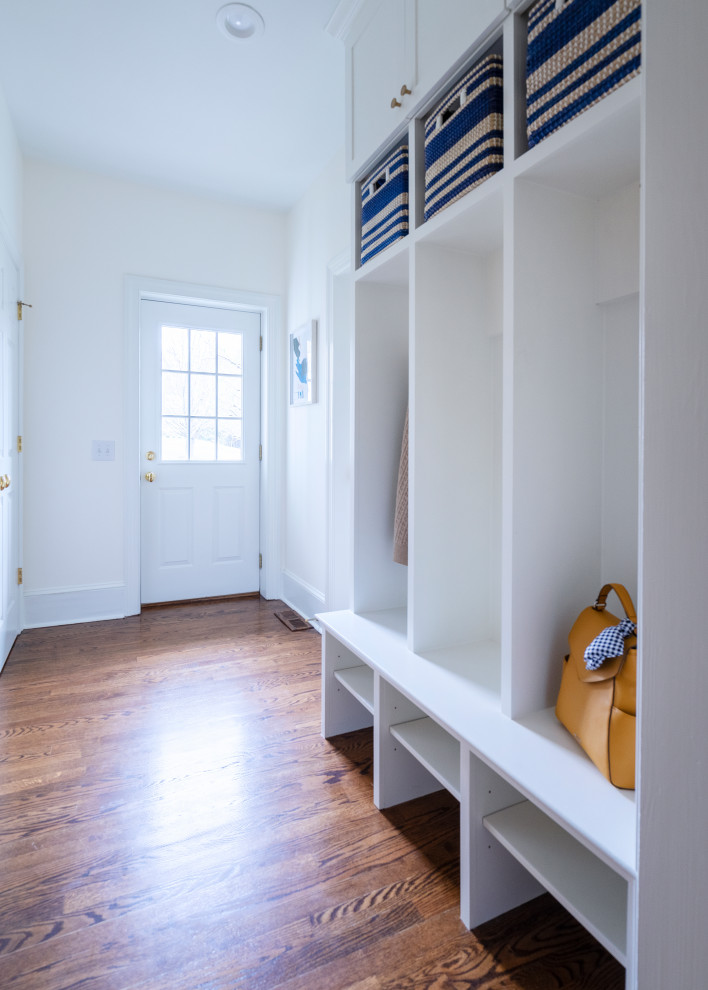 Inspiration for a transitional mudroom in Philadelphia with white walls, dark hardwood floors and brown floor.