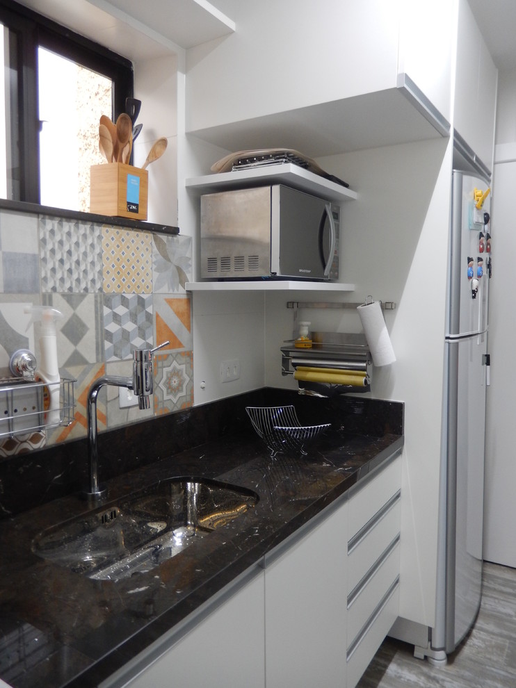 Design ideas for a small contemporary galley separate kitchen in Other with an undermount sink, white cabinets, marble benchtops, multi-coloured splashback, porcelain splashback, white appliances, porcelain floors and no island.