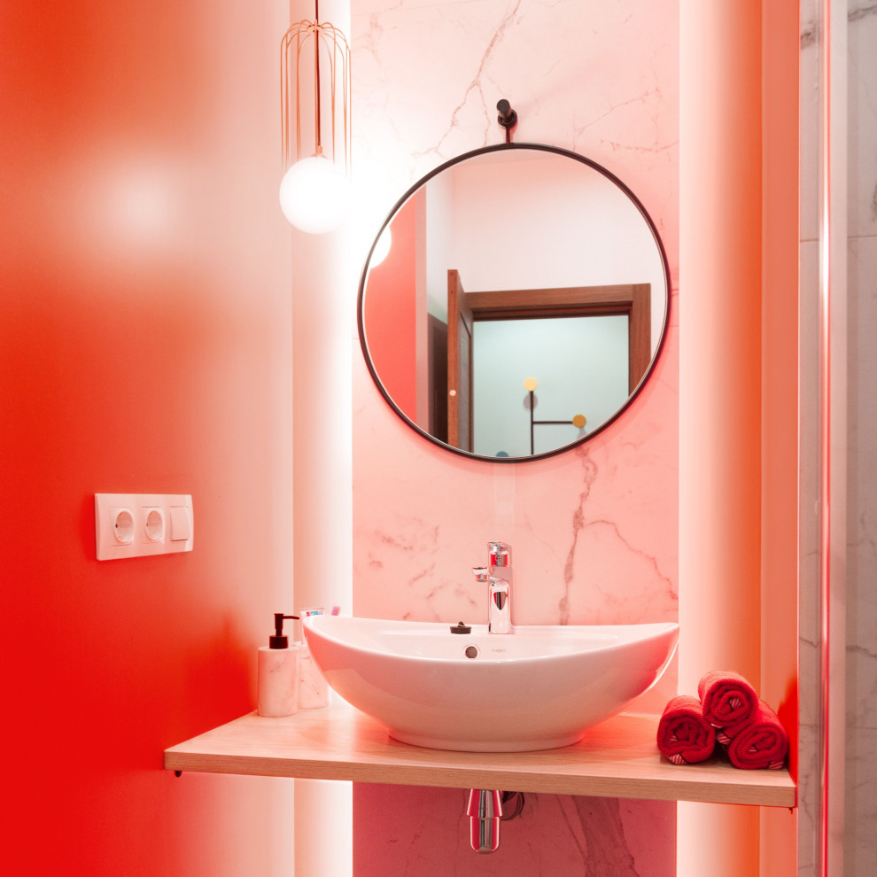 Пример оригинального дизайна: маленькая ванная комната со стиральной машиной в современном стиле с душем в нише, инсталляцией, белой плиткой, керамогранитной плиткой, оранжевыми стенами, полом из керамогранита, душевой кабиной, накладной раковиной, столешницей из дерева, бежевым полом, душем с распашными дверями, бежевой столешницей и тумбой под одну раковину для на участке и в саду