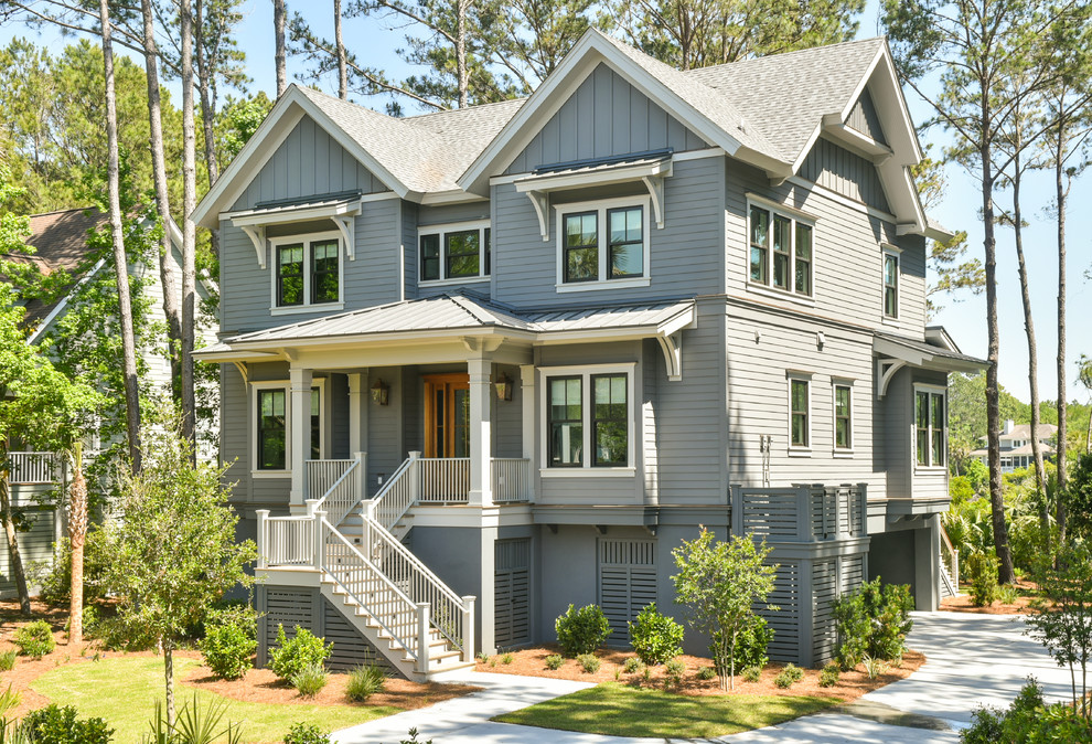 Large transitional two-storey concrete grey house exterior in Charleston with a mixed roof.