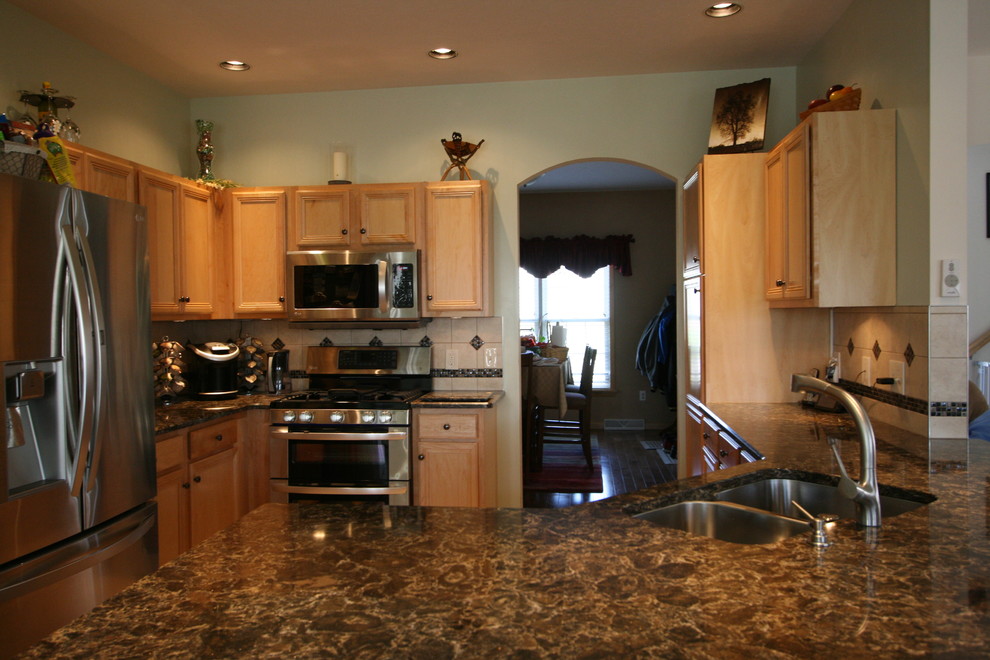 Inspiration for a mid-sized transitional l-shaped ceramic tile open concept kitchen remodel with an undermount sink, recessed-panel cabinets, light wood cabinets, quartz countertops, beige backsplash, ceramic backsplash, stainless steel appliances, green walls and a peninsula