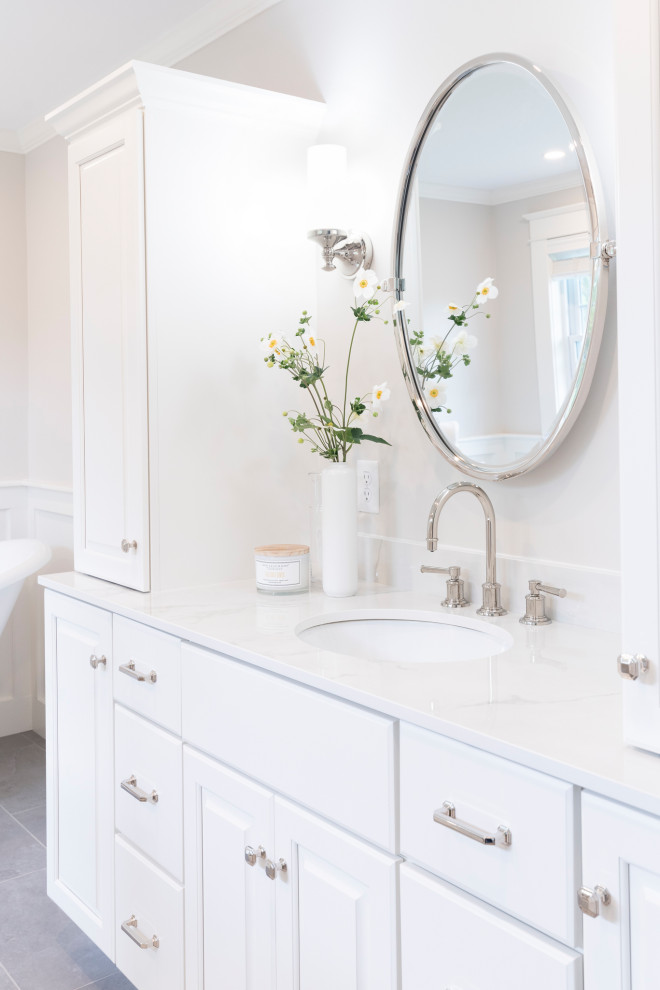 Mid-sized traditional master bathroom in Burlington with raised-panel cabinets, white cabinets, a freestanding tub, a two-piece toilet, grey walls, ceramic floors, an undermount sink, grey floor, a hinged shower door, white benchtops, a shower seat, a single vanity, a freestanding vanity and decorative wall panelling.