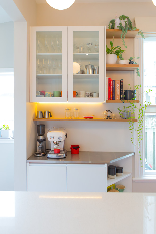 Photo of a mid-sized eclectic galley eat-in kitchen in Wellington with a single-bowl sink, quartz benchtops, white splashback, ceramic splashback, stainless steel appliances, medium hardwood floors and with island.
