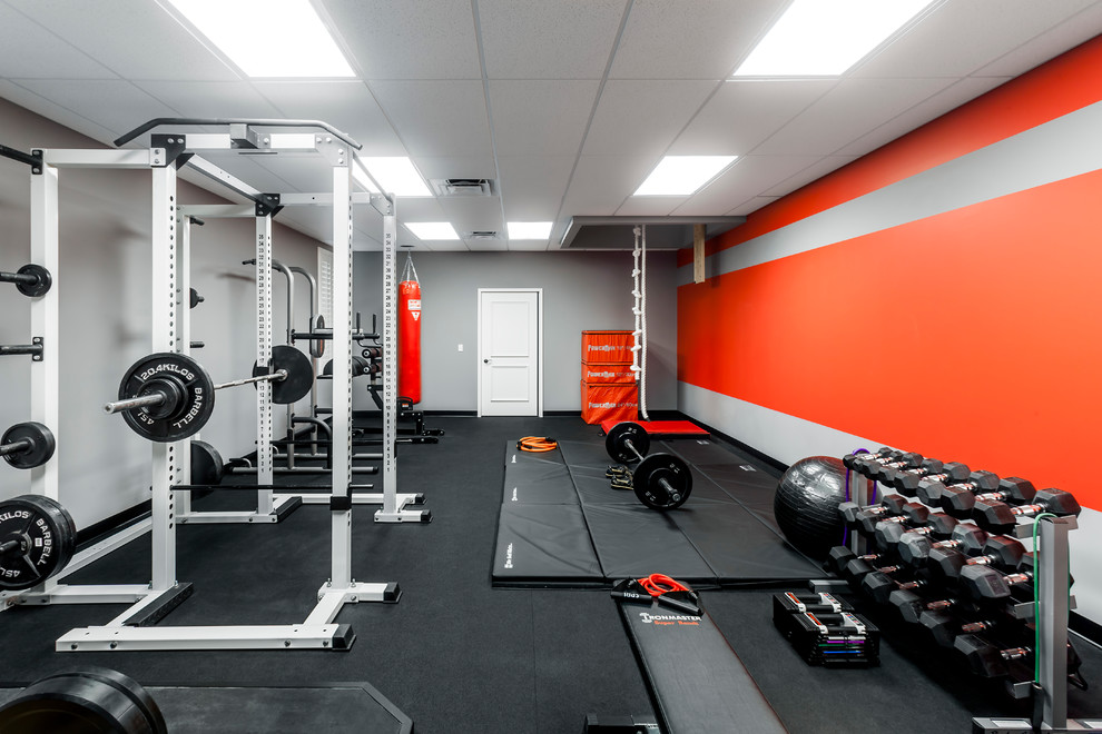 Large modern home weight room in Orlando with grey walls and black floor.