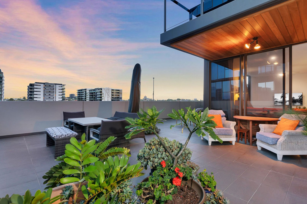 Inspiration for an expansive contemporary deck in Brisbane with a container garden and a roof extension.