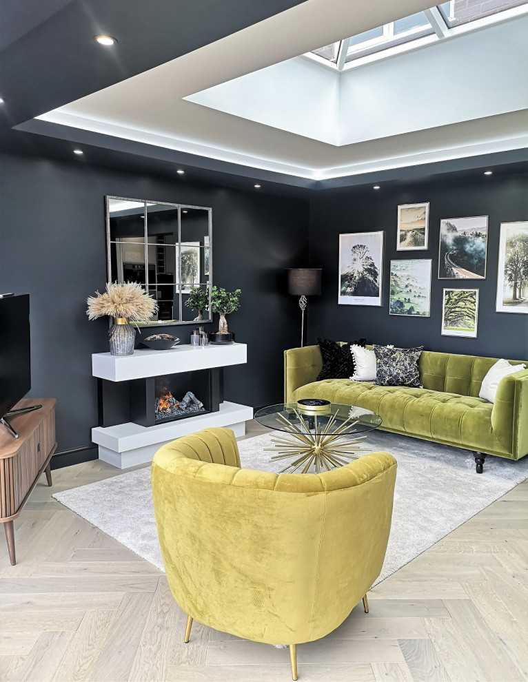 Inspiration for a medium sized retro living room in London with black walls, light hardwood flooring, a standard fireplace, a freestanding tv and beige floors.