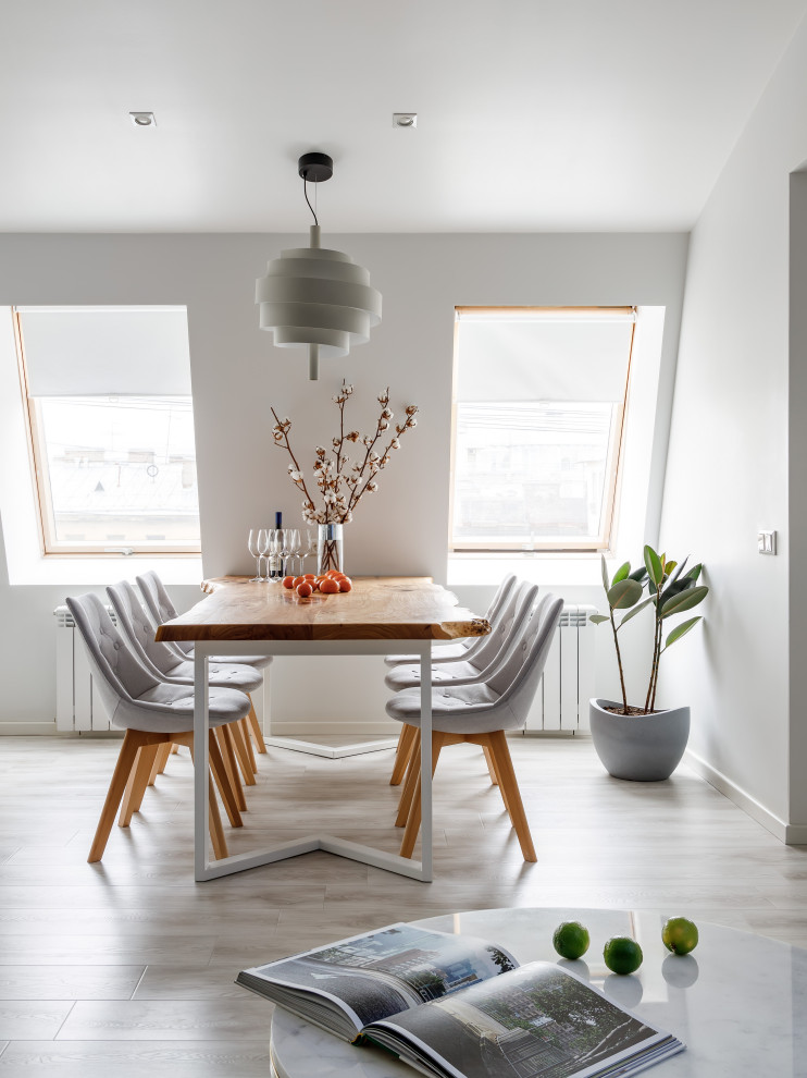 Esempio di una grande sala da pranzo aperta verso la cucina scandinava con pareti bianche, parquet chiaro, pavimento beige e travi a vista