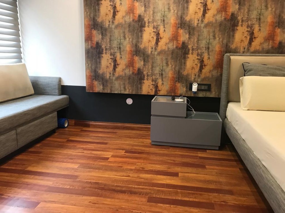 Photo of a large industrial master bedroom in Sydney with white walls, laminate floors and orange floor.