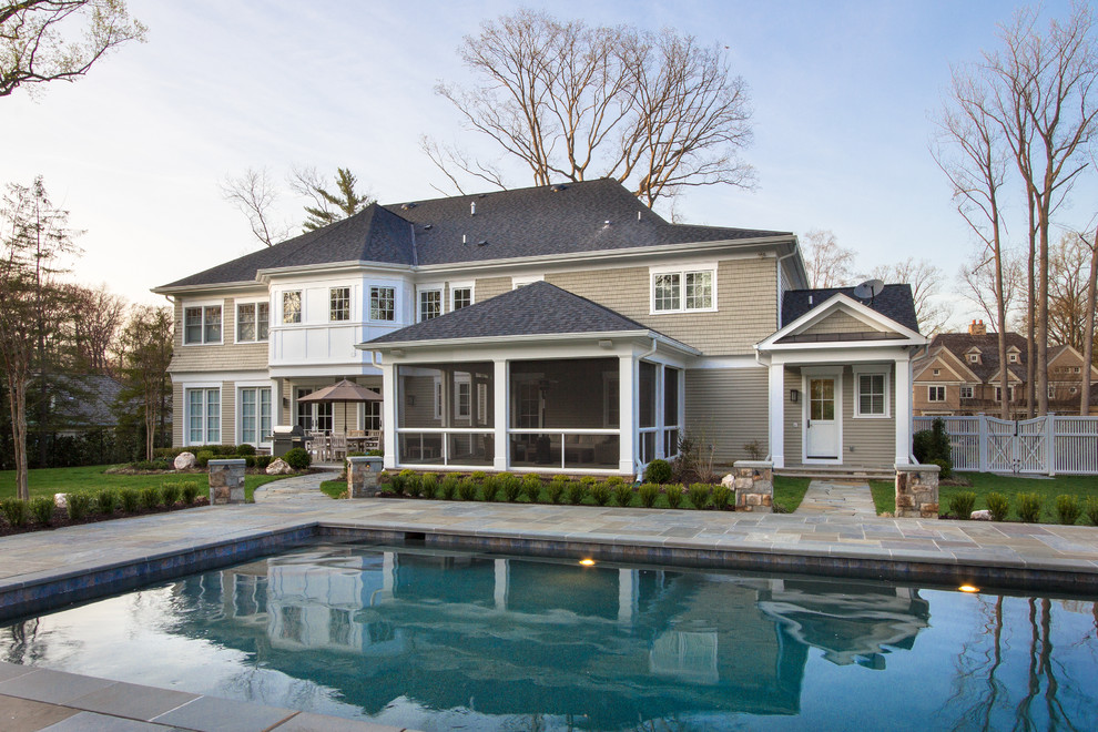Inspiration for a transitional backyard rectangular pool in DC Metro with natural stone pavers.