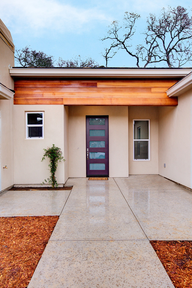 Mid-sized contemporary one-storey stucco beige house exterior in Sacramento with a gable roof and a shingle roof.