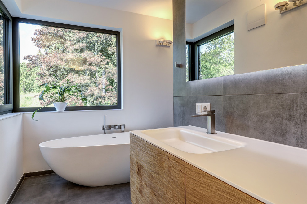 Contemporary bathroom in Frankfurt with a double vanity, a floating vanity, a freestanding tub, gray tile, white walls, wood benchtops, grey floor, an open shower and white benchtops.