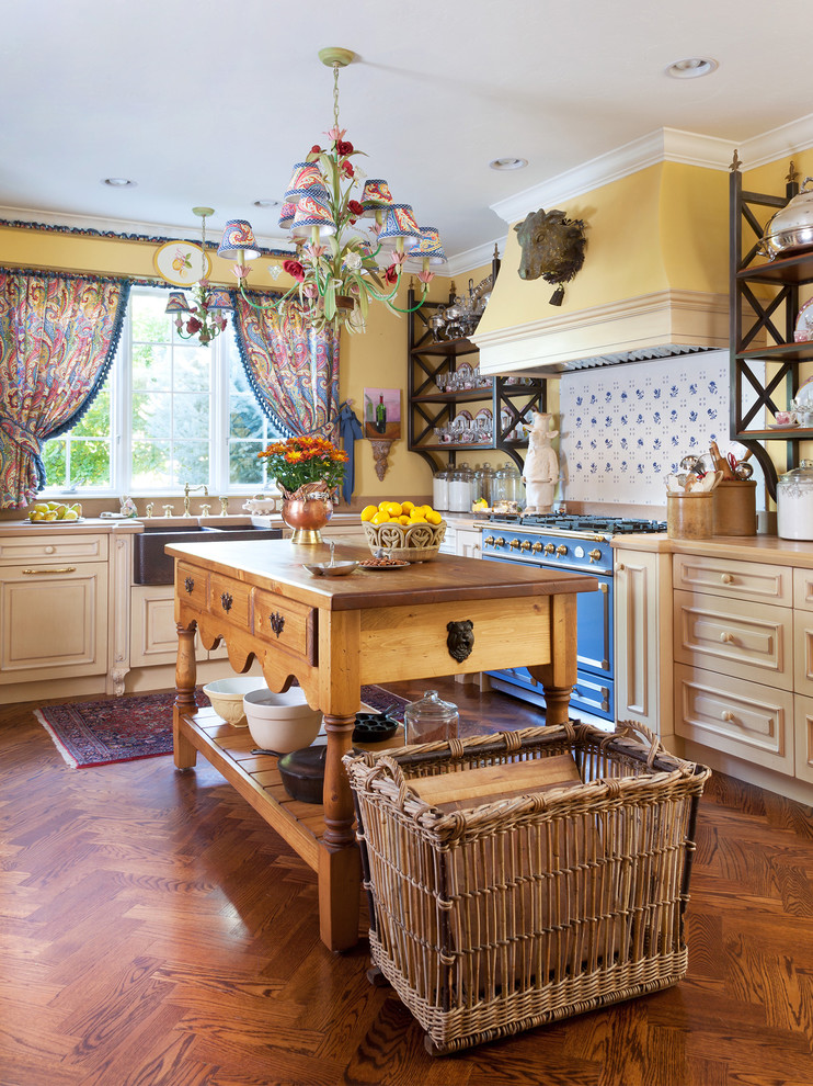 Design ideas for a country kitchen in Denver with a farmhouse sink, raised-panel cabinets, beige cabinets, multi-coloured splashback, ceramic splashback, coloured appliances, medium hardwood floors and with island.