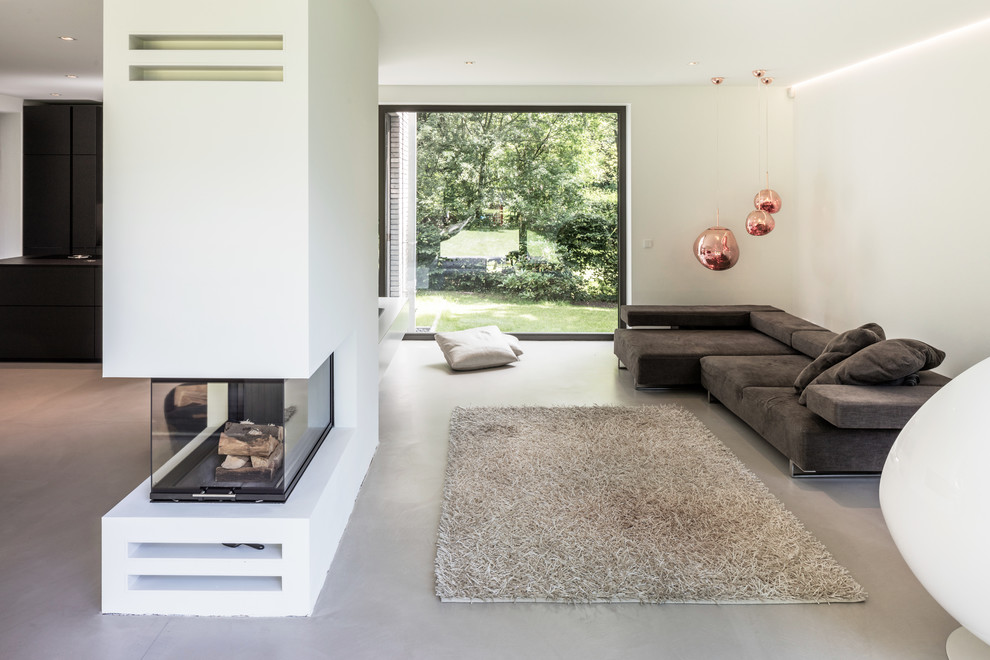 Inspiration for a contemporary open concept family room in Hamburg with white walls, concrete floors and grey floor.