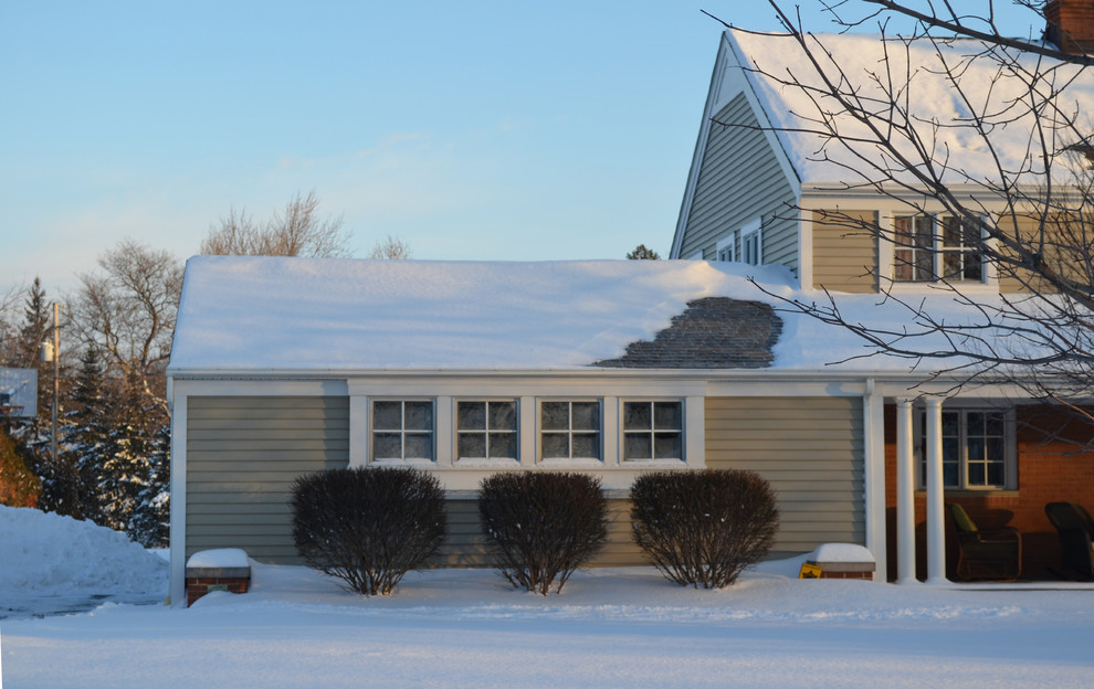 Photo of a mid-sized traditional two-storey beige exterior in Cleveland with vinyl siding.