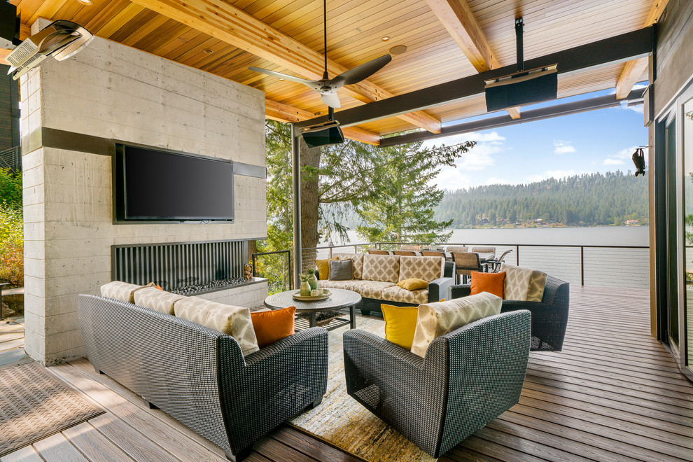 Design ideas for a contemporary deck in Seattle with with fireplace and a roof extension.