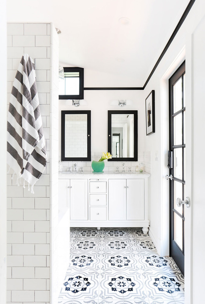 This is an example of a mid-sized scandinavian master bathroom in Los Angeles with recessed-panel cabinets, white cabinets, black and white tile, cement tile, white walls, an undermount sink, marble benchtops, mosaic tile floors and multi-coloured floor.