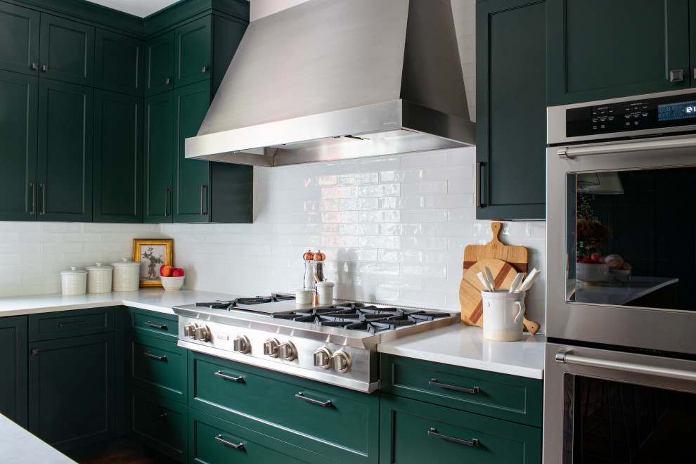 Enclosed kitchen - large transitional u-shaped dark wood floor and brown floor enclosed kitchen idea in Seattle with a farmhouse sink, recessed-panel cabinets, green cabinets, quartz countertops, white backsplash, porcelain backsplash, stainless steel appliances, an island and white countertops