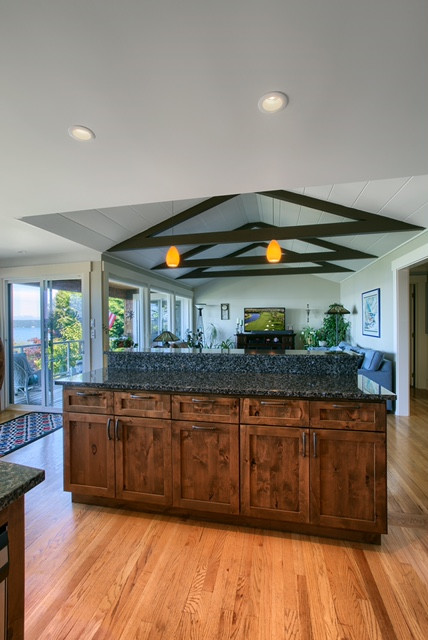 Inspiration for a large rustic u-shaped light wood floor eat-in kitchen remodel in Seattle with a double-bowl sink, recessed-panel cabinets, distressed cabinets, quartz countertops, beige backsplash, ceramic backsplash, stainless steel appliances and an island