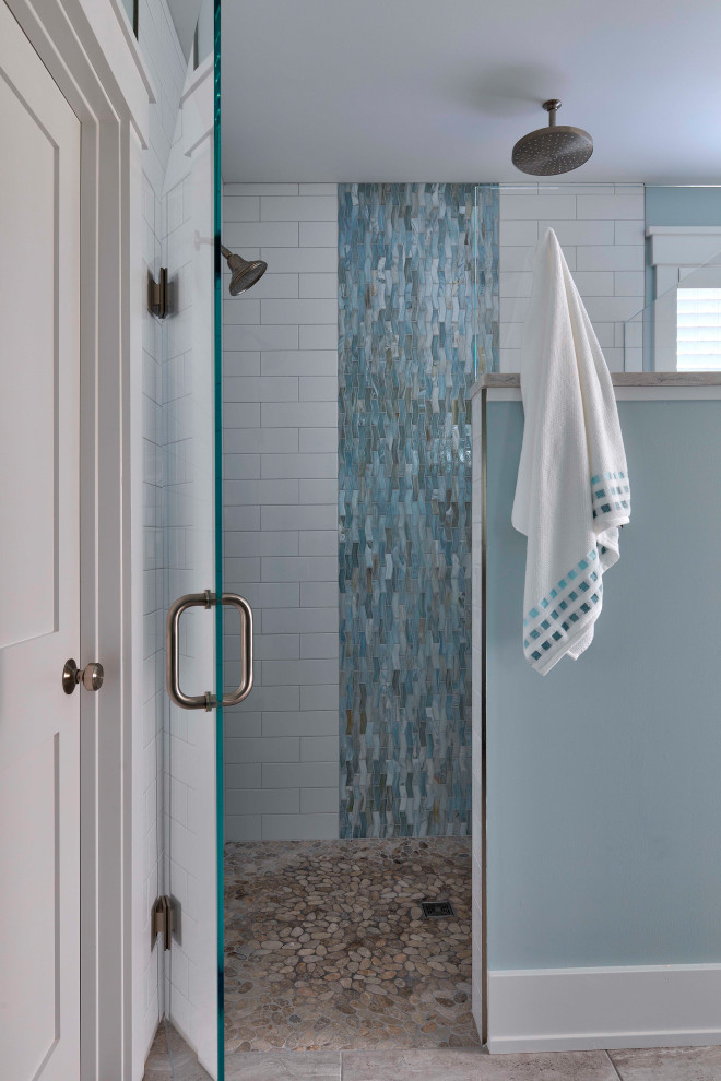 Foto di una grande stanza da bagno padronale tradizionale con doccia doppia, piastrelle bianche, piastrelle di vetro, pavimento con piastrelle di ciottoli, pavimento beige e porta doccia a battente