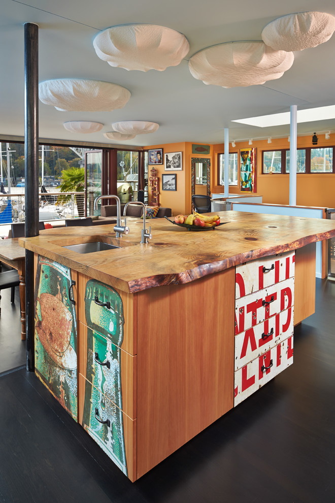 Photo of an eclectic open plan kitchen in Seattle with an undermount sink, flat-panel cabinets and wood benchtops.