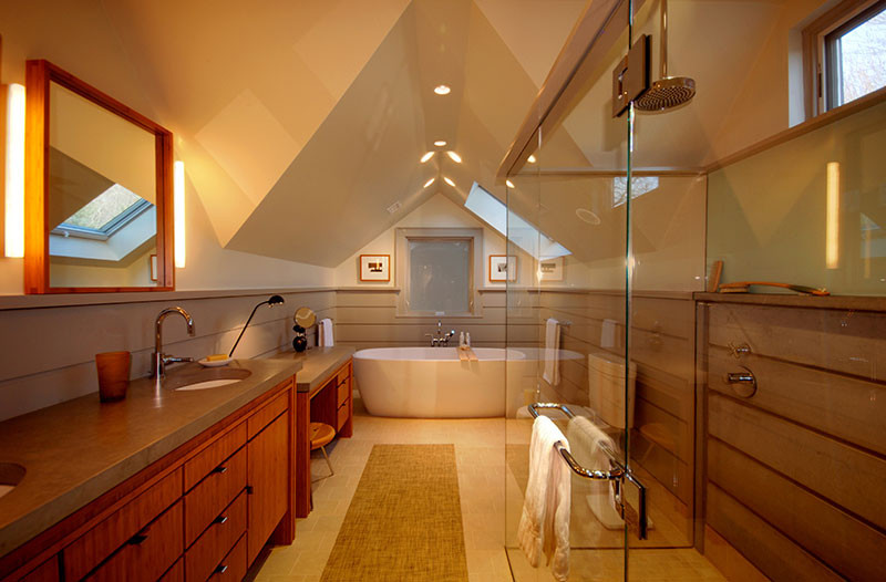 Design ideas for a mid-sized contemporary master bathroom in Boston with medium wood cabinets, a freestanding tub, gray tile, cement tile, an undermount sink, concrete benchtops, furniture-like cabinets, a corner shower, a two-piece toilet, grey walls, limestone floors, beige floor, a hinged shower door and grey benchtops.