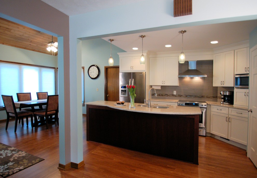 Small transitional single-wall medium tone wood floor eat-in kitchen photo in Columbus with an undermount sink, shaker cabinets, white cabinets, granite countertops, gray backsplash, ceramic backsplash, stainless steel appliances and an island