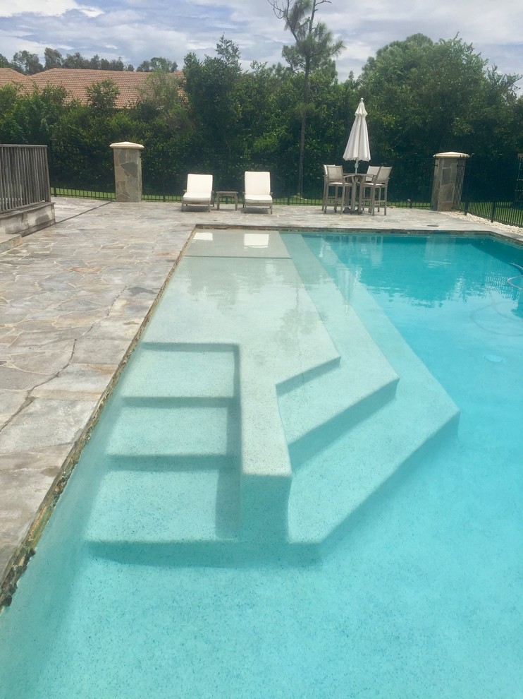 Example of a large island style backyard stone and rectangular lap pool design