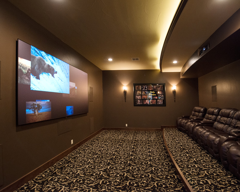 Photo of a mediterranean home theatre in Austin with brown walls, carpet, a projector screen and multi-coloured floor.
