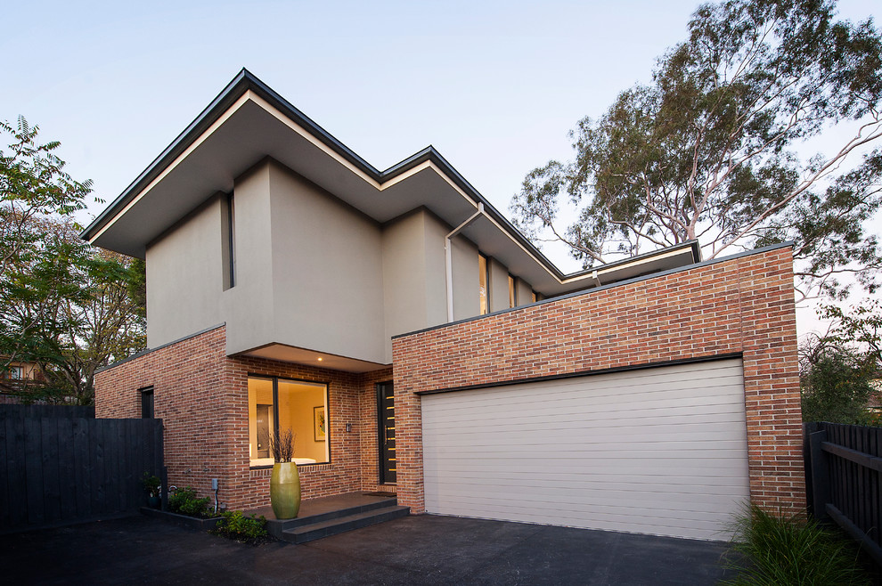 Photo of a contemporary two-storey grey exterior in Melbourne with mixed siding and a flat roof.