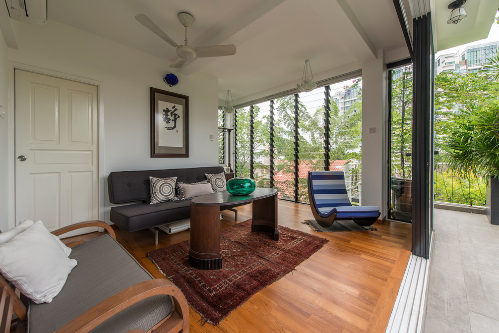 Family room - transitional medium tone wood floor family room idea in Singapore with white walls, no fireplace and no tv