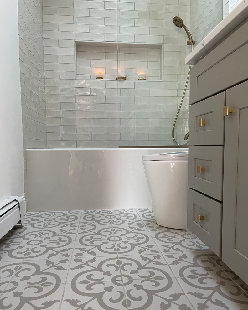 This is an example of a small classic ensuite bathroom in DC Metro with recessed-panel cabinets, grey cabinets, an alcove bath, all types of shower, a one-piece toilet, white tiles, white walls, ceramic flooring, a built-in sink, granite worktops, multi-coloured floors, white worktops, a wall niche and a single sink.
