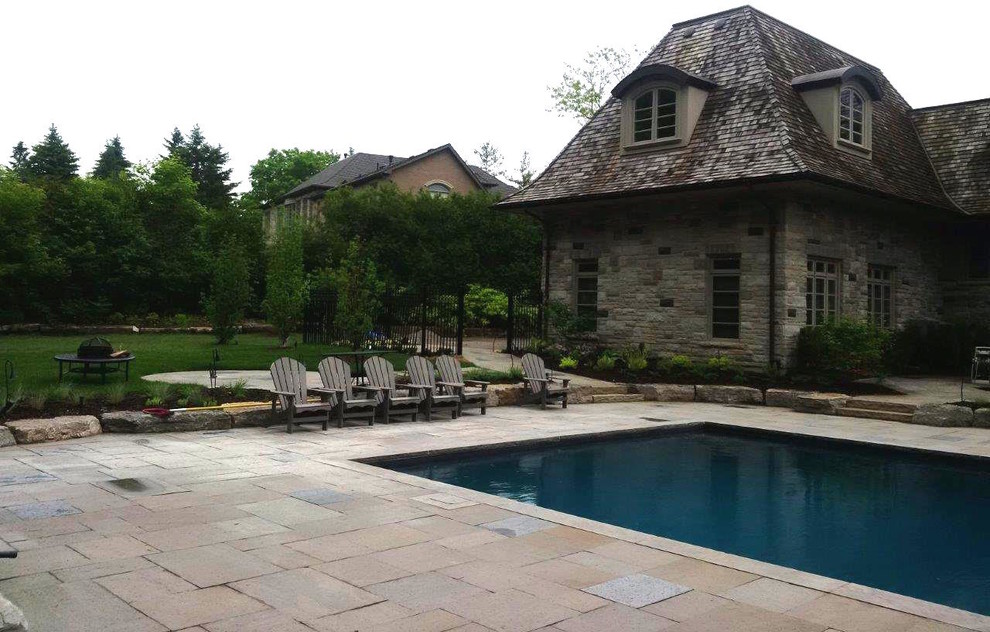 Inspiration for a large traditional backyard patio in Toronto with natural stone pavers and no cover.