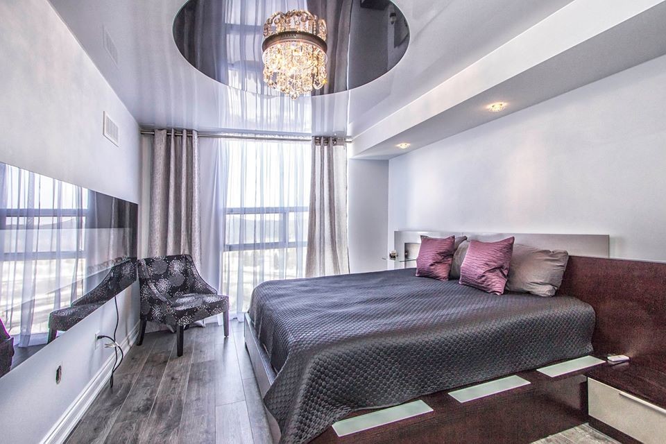 Photo of a mid-sized modern master bedroom in Toronto with white walls, medium hardwood floors, a ribbon fireplace and a metal fireplace surround.