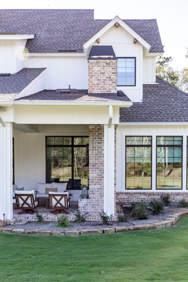 Großes, Zweistöckiges Country Einfamilienhaus mit Faserzement-Fassade, weißer Fassadenfarbe, Walmdach, Schindeldach, schwarzem Dach und Wandpaneelen in Houston