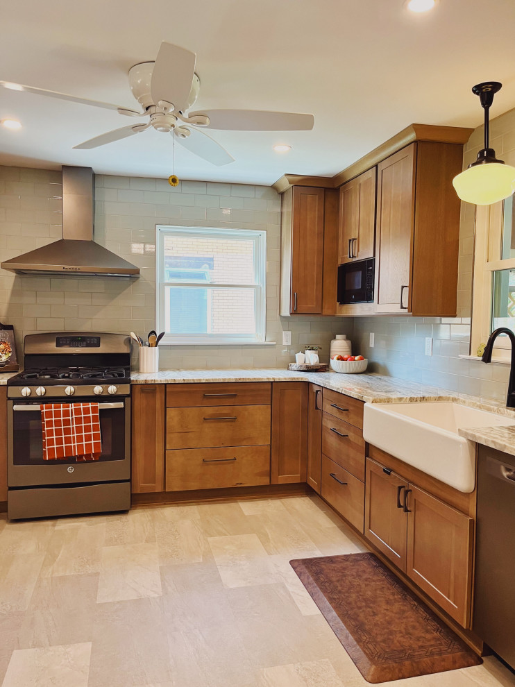 Inspiration for a mid-sized transitional l-shaped vinyl floor and beige floor eat-in kitchen remodel with a farmhouse sink, shaker cabinets, medium tone wood cabinets, quartzite countertops, green backsplash, ceramic backsplash, stainless steel appliances, no island and beige countertops